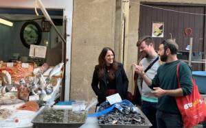 Guide with a couple of tourists at the fish stall